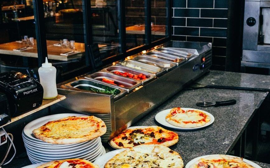 Tranci di pizza esposti al banco